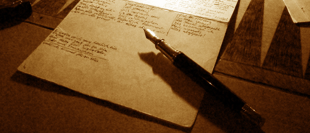 Ein Füllfederhalter auf einem Blatt Papier mit Ideen, Kerzenschein fällt von hinten drauf